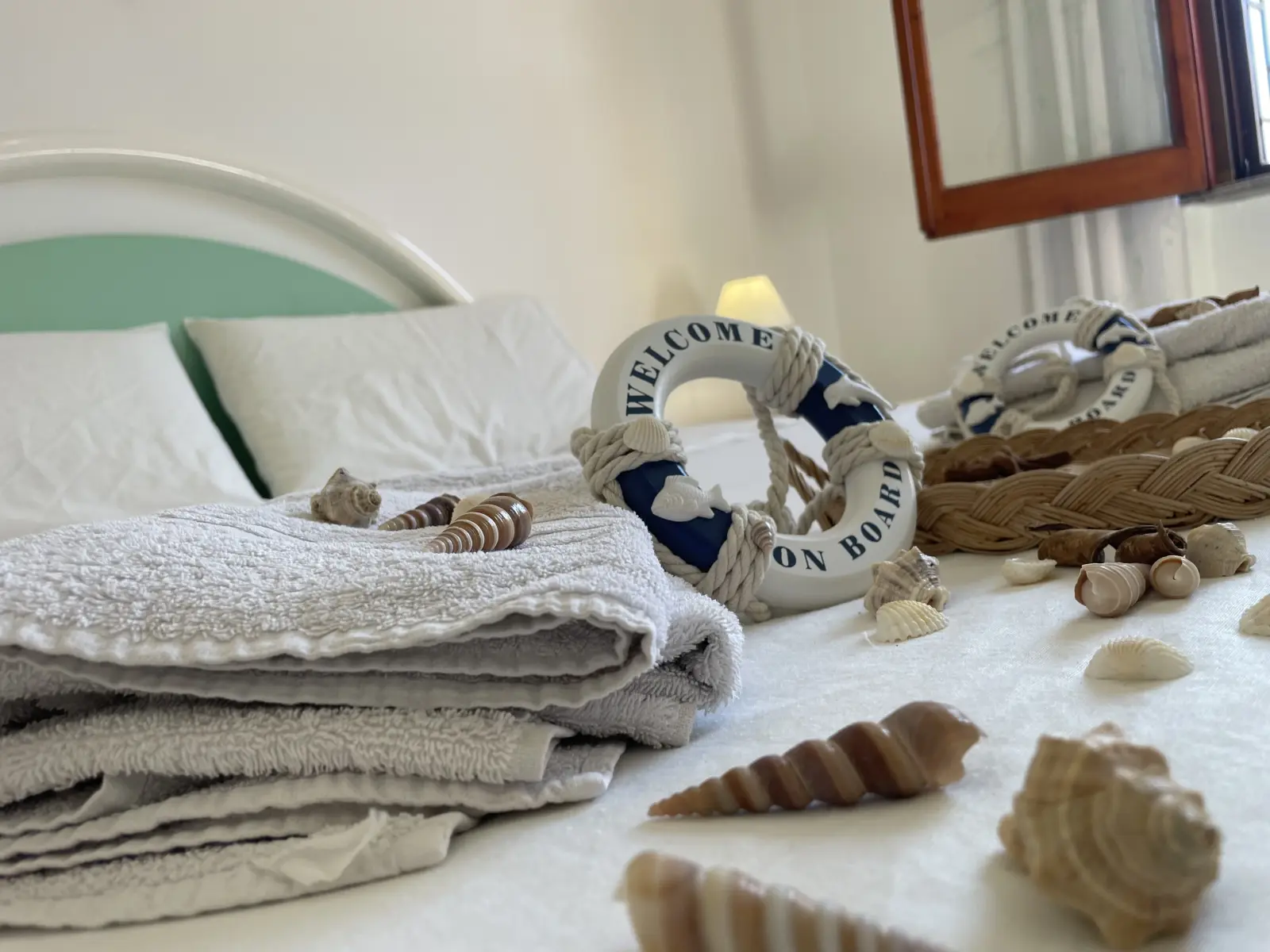 Dettaglio letto con asciugamani e decorazioni marine nella camera di Casa delle Ginestre